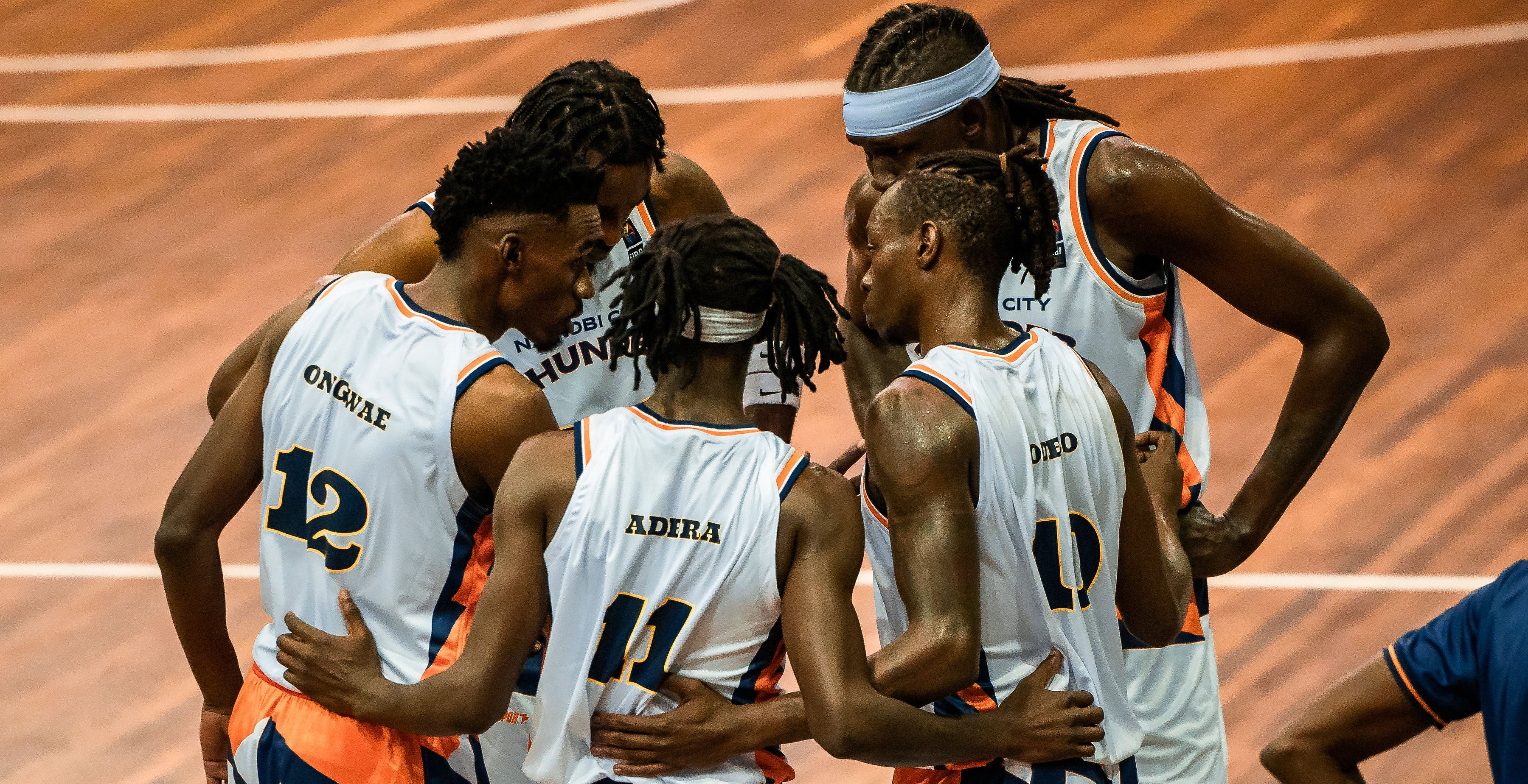Basketball players huddled together on a court
